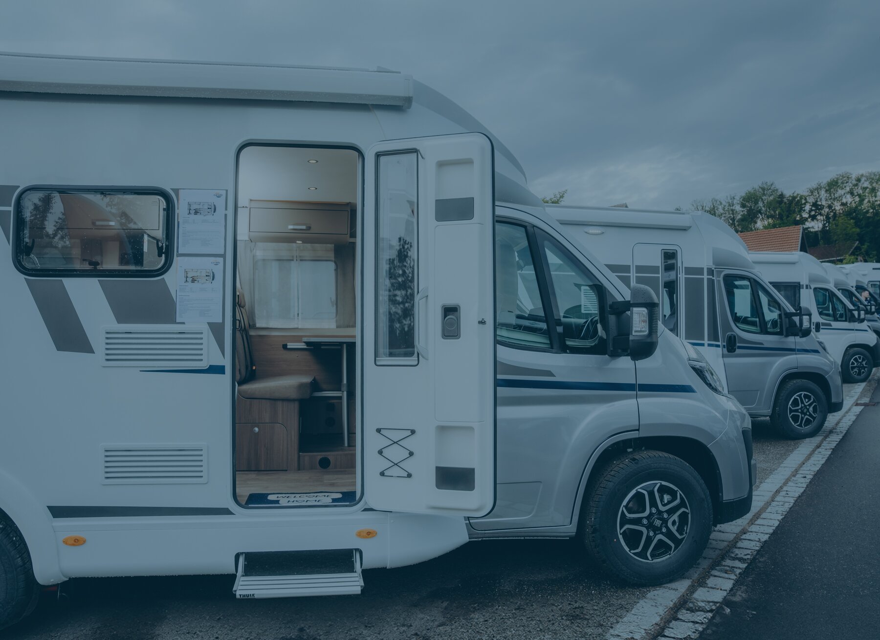 Carado Wohnmobil auf Stellplatz mit geöffneter Aufbautür und Blick in den Innenraum