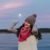 Front view of a woman, dusk in the background, a lake and forest behind